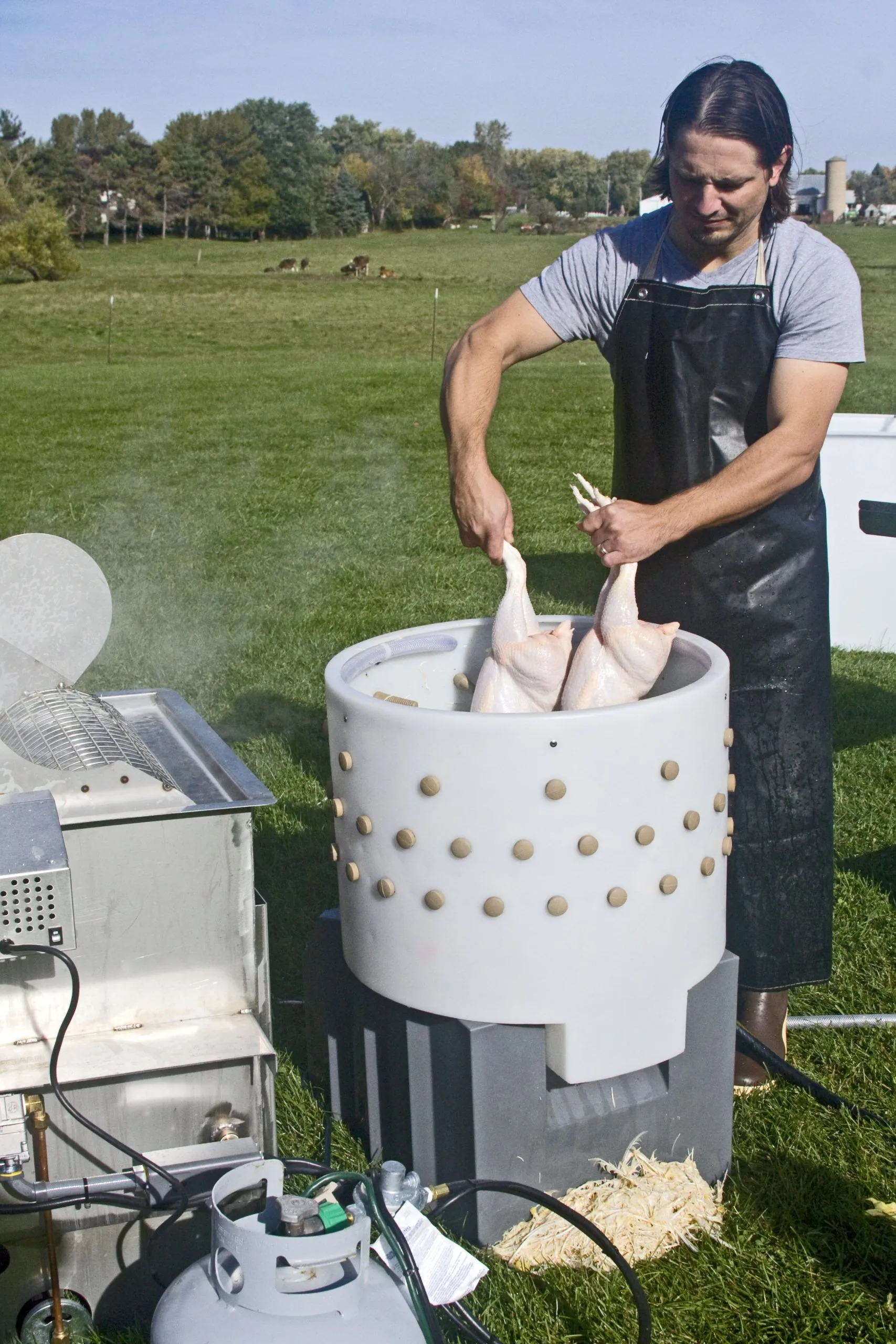 Man processing chicken in Featherman PRO - Chicken Plucker Machine